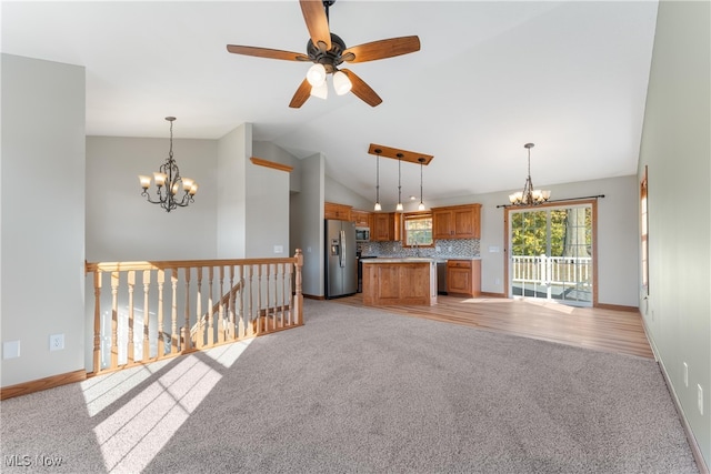 unfurnished living room featuring light hardwood / wood-style floors, lofted ceiling, and ceiling fan with notable chandelier