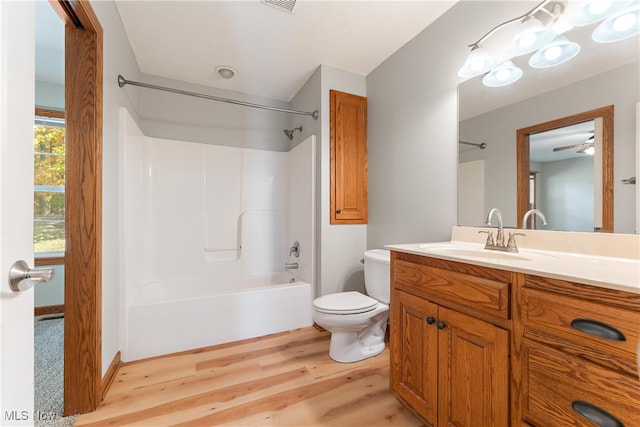 full bathroom featuring toilet, shower / tub combination, hardwood / wood-style flooring, and vanity