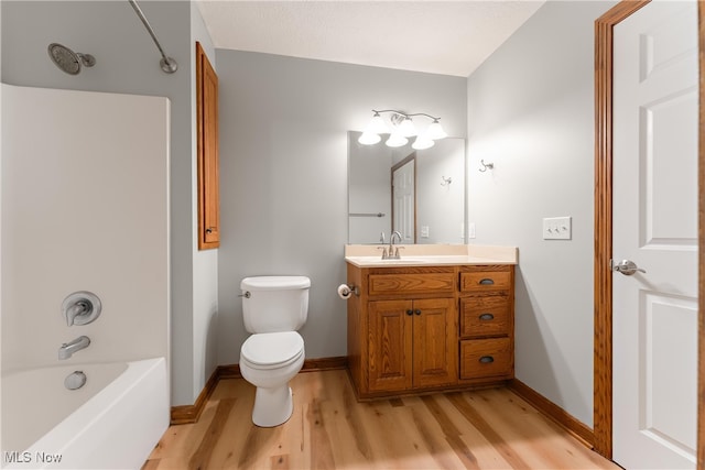 full bathroom with toilet, hardwood / wood-style flooring, vanity, and bathing tub / shower combination