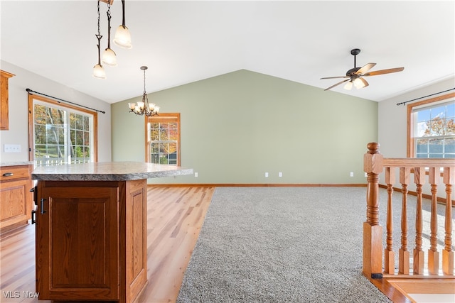 kitchen featuring light hardwood / wood-style flooring, lofted ceiling, a wealth of natural light, and decorative light fixtures