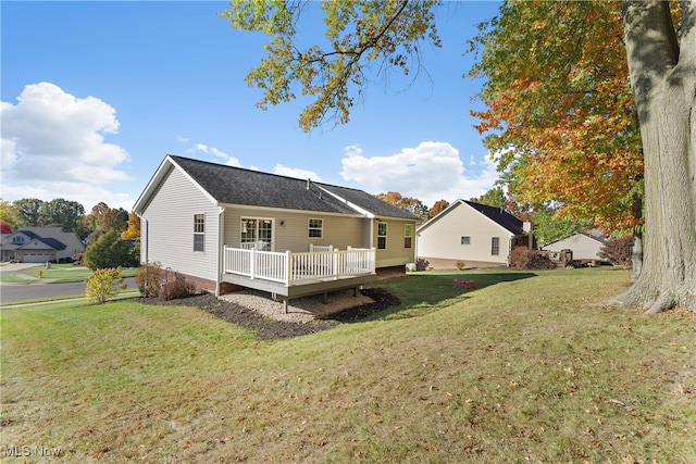 rear view of house with a deck and a lawn