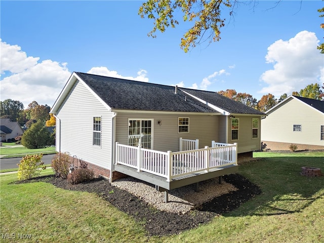 back of house featuring a deck and a yard