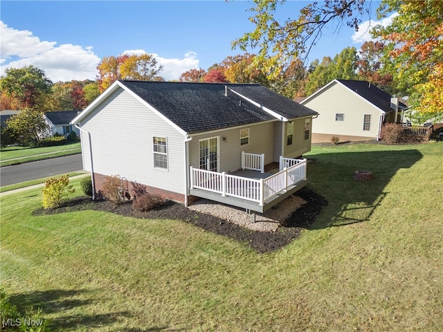 rear view of house featuring a deck and a lawn