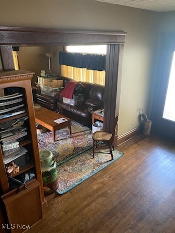 living room featuring a textured ceiling and dark hardwood / wood-style flooring