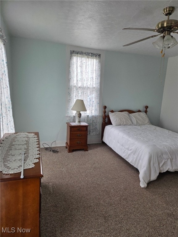 bedroom with carpet floors, ceiling fan, and a textured ceiling