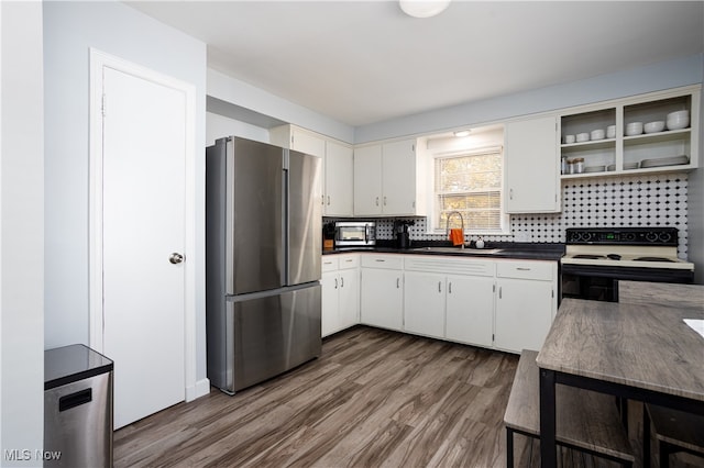 kitchen with sink, decorative backsplash, white cabinetry, white range with electric stovetop, and stainless steel refrigerator