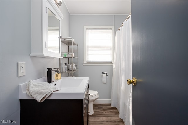 bathroom with vanity, crown molding, wood-type flooring, and toilet