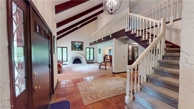 tiled foyer entrance featuring beam ceiling, a chandelier, and high vaulted ceiling