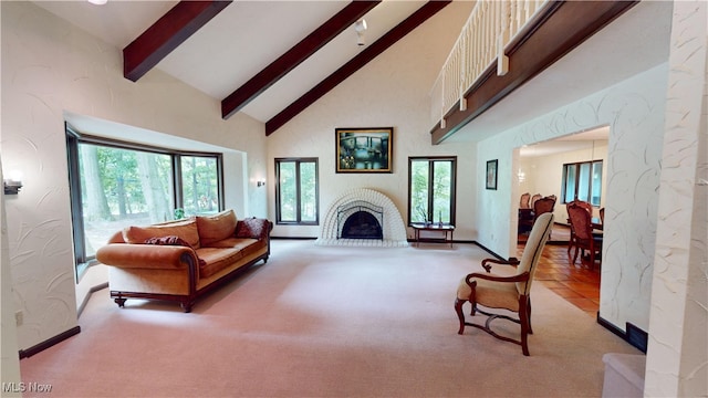 living room featuring beam ceiling, light colored carpet, and high vaulted ceiling