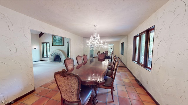 dining space with a fireplace and an inviting chandelier