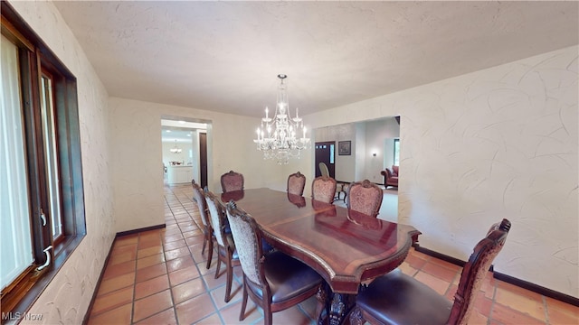 tiled dining room with a notable chandelier