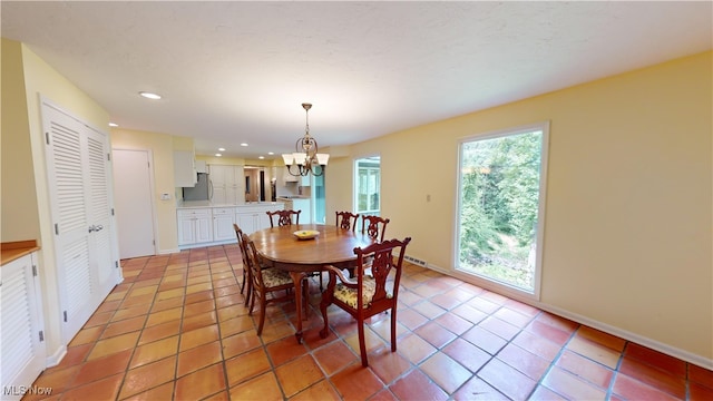 tiled dining room featuring a notable chandelier