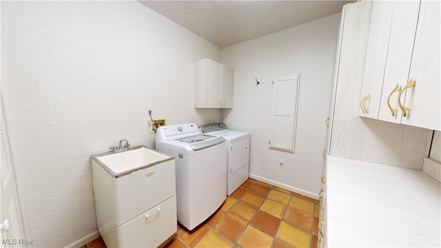 laundry room featuring cabinets, sink, and washer and clothes dryer