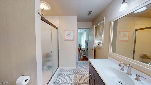 bathroom with vanity and a shower with door