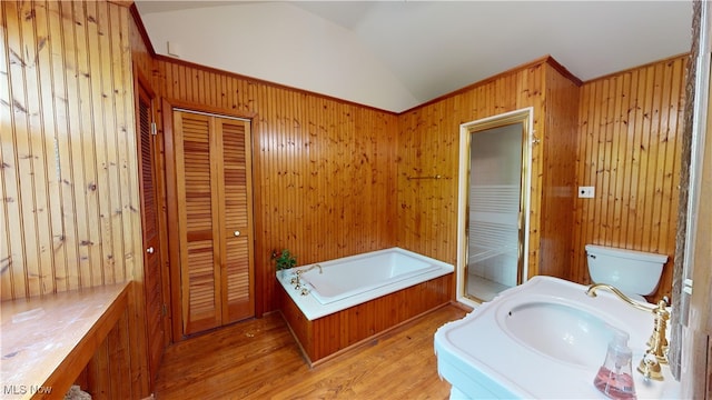 bathroom featuring toilet, wood walls, wood-type flooring, and vaulted ceiling