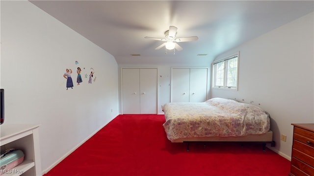 carpeted bedroom featuring ceiling fan and two closets