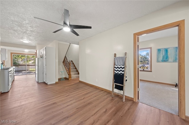 unfurnished living room with light hardwood / wood-style flooring and a textured ceiling