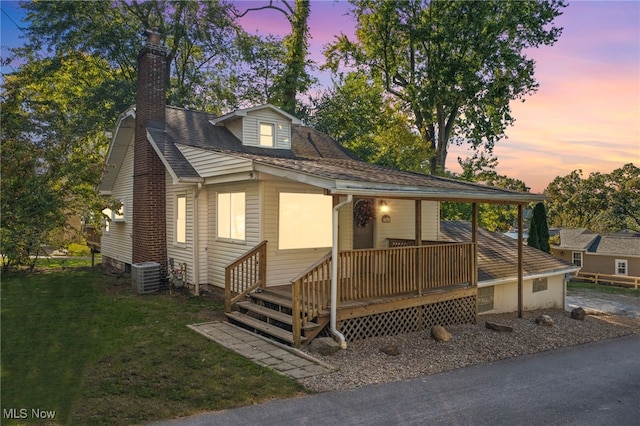 view of front of property with a yard and central AC unit