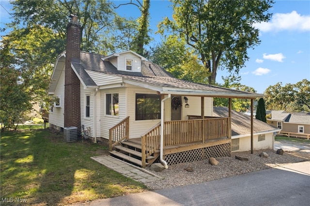 view of front of home with cooling unit and a front lawn