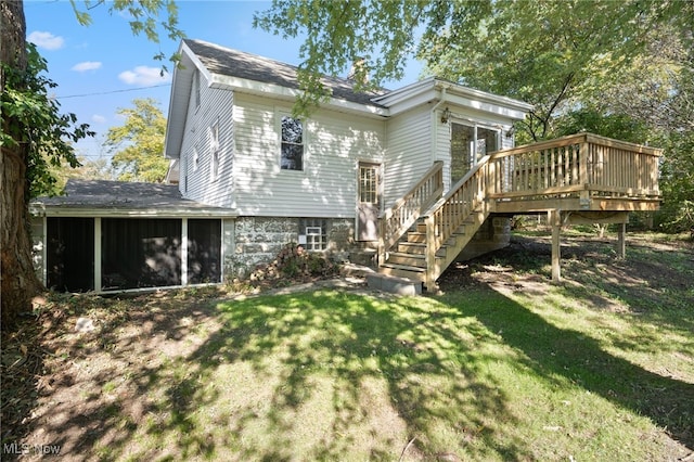 back of property featuring a wooden deck and a lawn