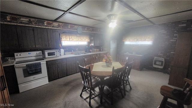 kitchen with white appliances, ceiling fan, light carpet, and sink