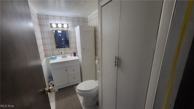 bathroom with vanity, ornamental molding, and toilet