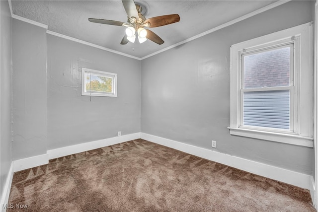 empty room with ceiling fan, baseboards, ornamental molding, and carpet