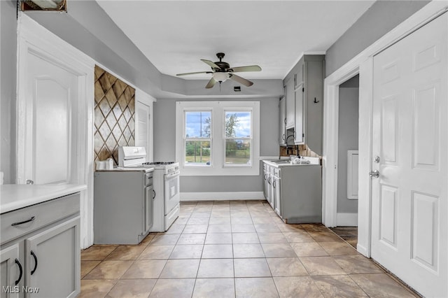 laundry room featuring ceiling fan and light tile patterned floors