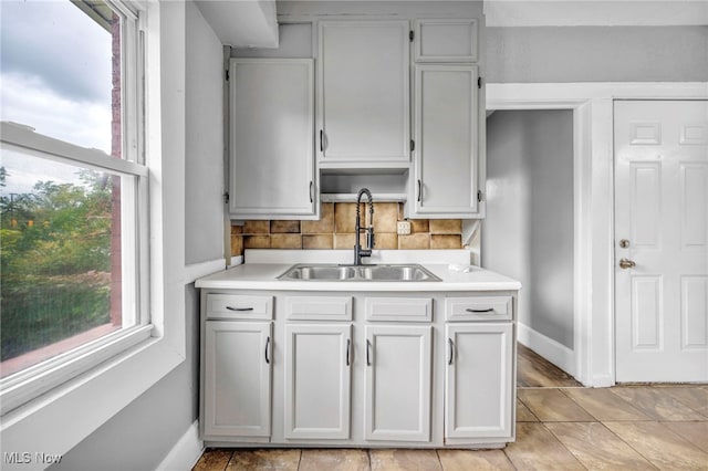 kitchen featuring light tile patterned floors, sink, backsplash, and plenty of natural light