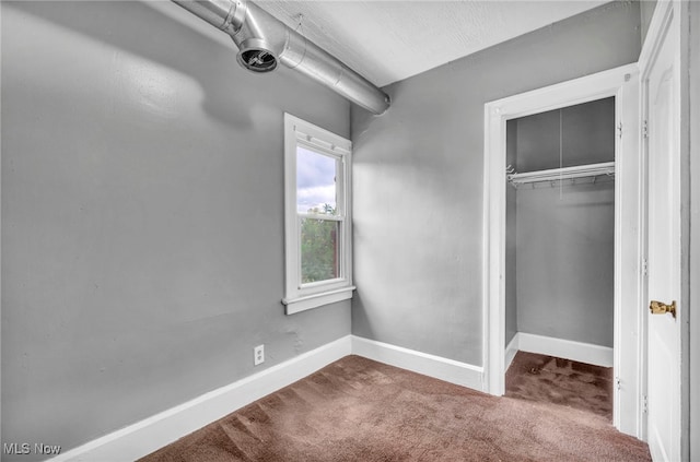 unfurnished bedroom featuring carpet, a closet, and baseboards
