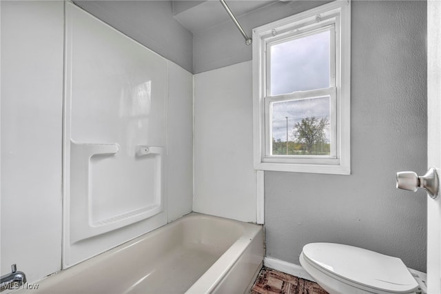 bathroom featuring bathtub / shower combination and toilet