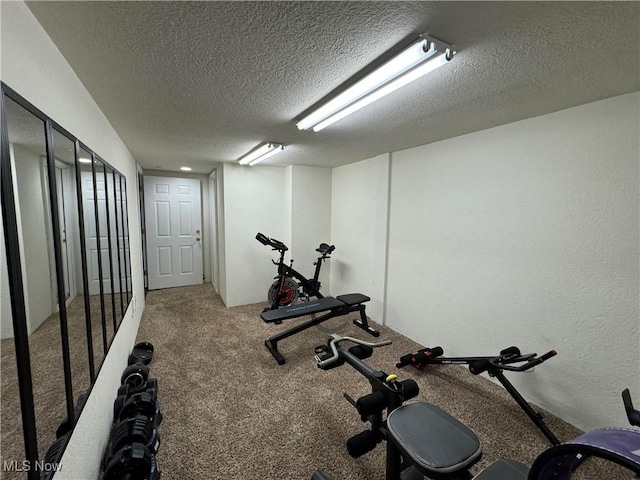 exercise area featuring carpet flooring and a textured ceiling