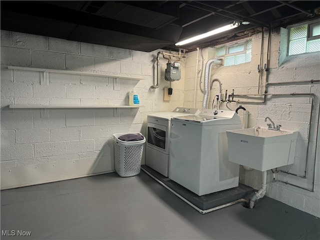 clothes washing area featuring washer and clothes dryer and sink