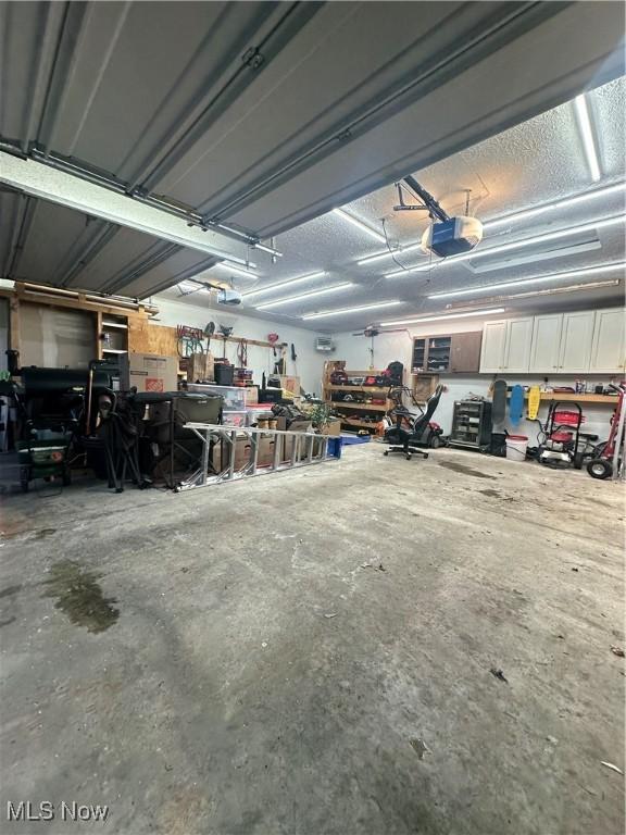 garage with a workshop area and a garage door opener