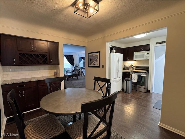 dining room with dark hardwood / wood-style floors and a textured ceiling