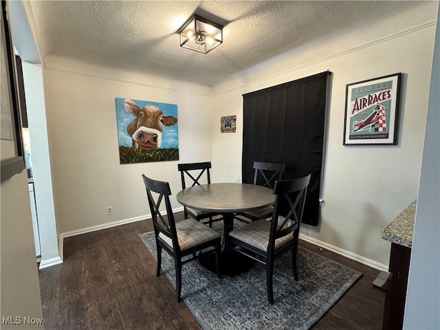 dining room with dark hardwood / wood-style flooring and a textured ceiling