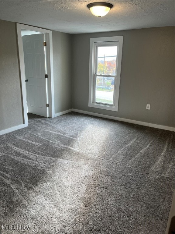 carpeted spare room with a textured ceiling