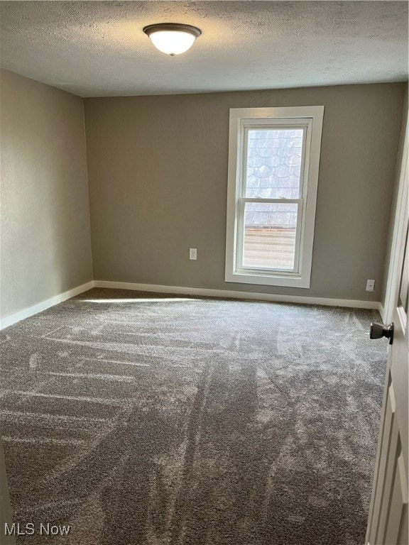 carpeted spare room featuring a textured ceiling