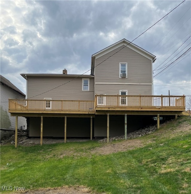 back of house with a deck and a lawn