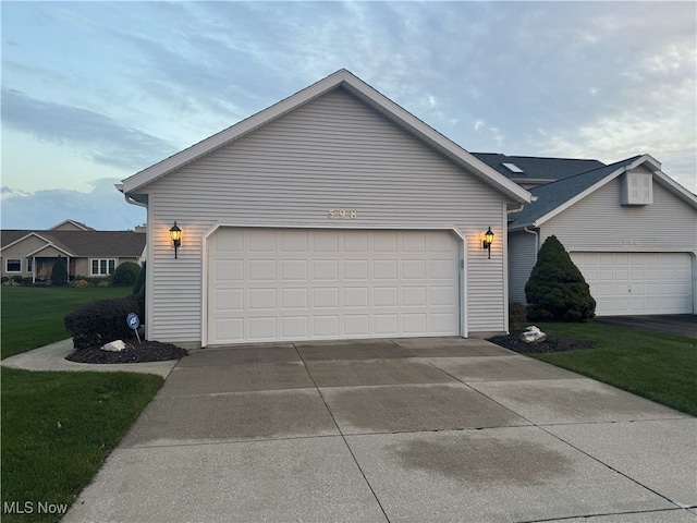 exterior space featuring a garage and a lawn