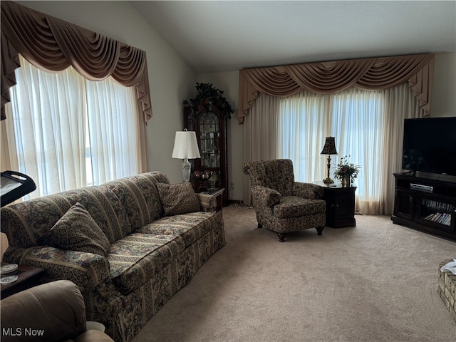 carpeted living room featuring vaulted ceiling