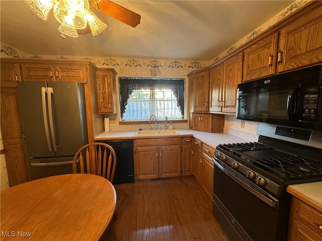 kitchen with dark wood-type flooring, black appliances, sink, and ceiling fan