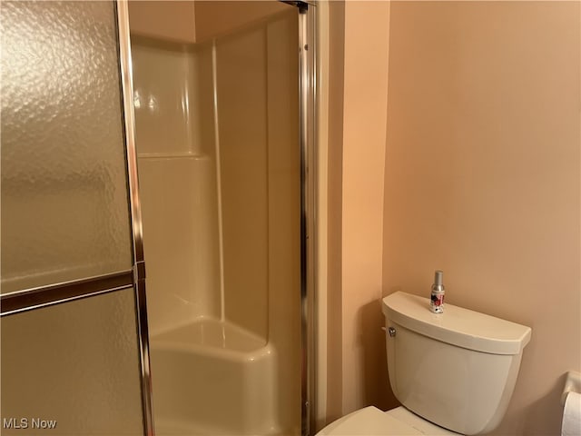 bathroom with toilet and a shower with shower door