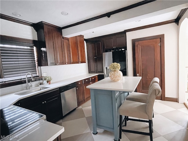 kitchen with appliances with stainless steel finishes, sink, a center island, and a breakfast bar