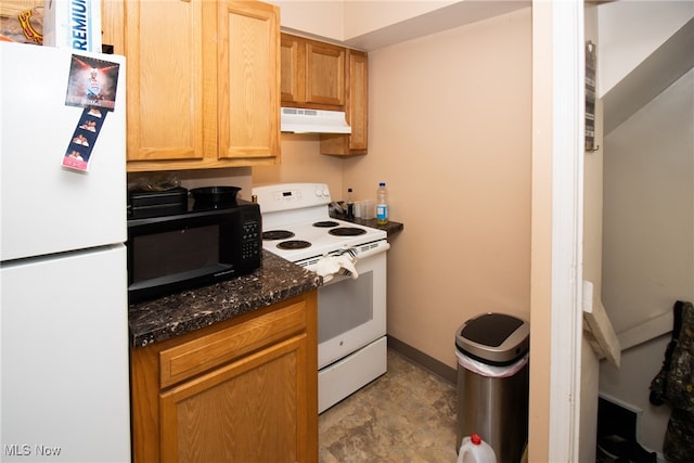 kitchen with white appliances and dark stone countertops