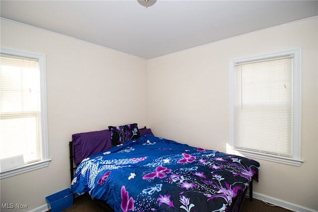 carpeted bedroom featuring multiple windows