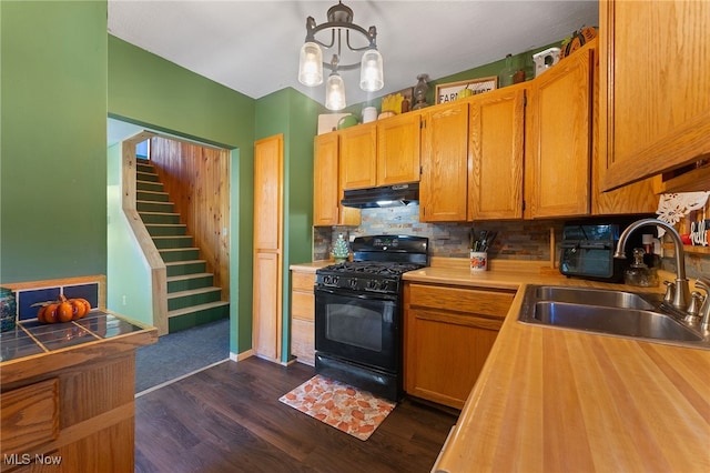 kitchen featuring backsplash, black range with gas stovetop, dark hardwood / wood-style floors, a notable chandelier, and sink