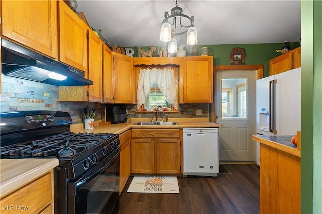 kitchen featuring a healthy amount of sunlight, gas stove, white dishwasher, and sink