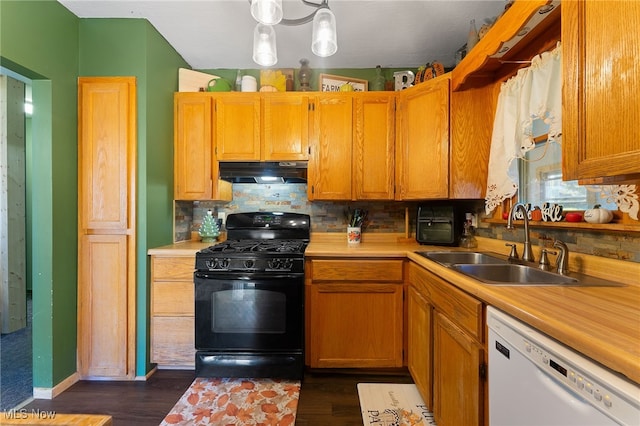 kitchen featuring sink, black gas stove, white dishwasher, hanging light fixtures, and dark wood-type flooring