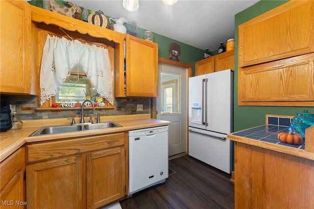 kitchen with dark hardwood / wood-style flooring, tasteful backsplash, sink, and white appliances